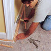 person installing tack strip to demonstrate how-to install carpet
