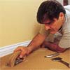 person using a carpet-edging tool to demonstrate how-to install carpet
