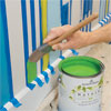 using a brush to cut in the stripes between arrows to paint a striped wall