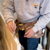 hands priming and painting the newly exposed parts of the door