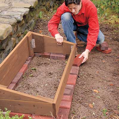 installing pavers around the the cold frame area as a stable foundation