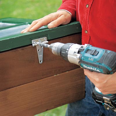 fastening the lid to the cold frame with a drill/driver
