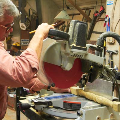 Tom Silva uses a miter saw to cut spindles to length