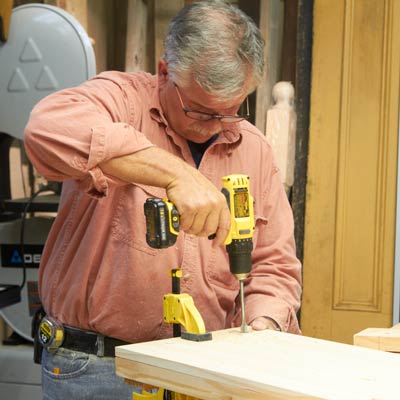 Tom Silva drills holes in the shelves
