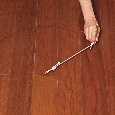 hand marking design on wood floor in preparation for painting medallion