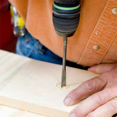 this old house general contractor drilling the holes for the wire while building a freestanding lamp