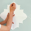 man using paper template to create painted wall design