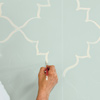 man painting moroccan wall design