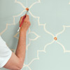 man painting moroccan wall design