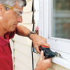 man sawing off rotted windowsill