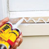 man applying adhesive for installing new windowsill