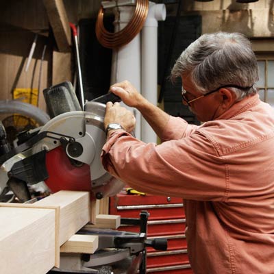 Tom Silva cuts the leg for a trestle table with a miter saw