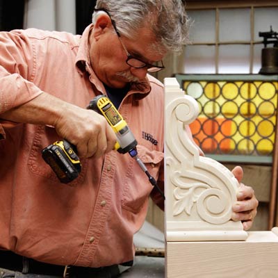 Tom Silva attaches the corbel for a trestle table to the base of the table leg