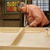 Tom Silva attaches stringers to the table top for a trestle table