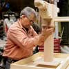 Tom Silva positions the leg assembly to the underside of the table top for a trestle table