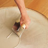spreading an even layer of wood flooring adhesive into the subfloor area of the circle