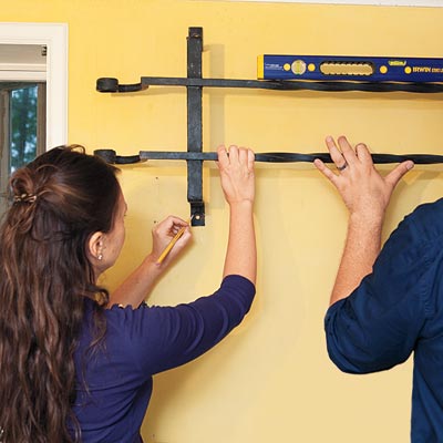 Amy Hughes and helper mark locations for the fasteners using a pencil and a level