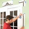 Mark Powers tapes a printout of the stencil pattern around the French doors for reference
