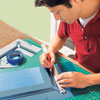 Mark Powers cuts the straight lines of the stencil pattern with an X-Acto knife and a straightedge