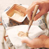 loading a stencil brush with paint and dabbing it on a lint-free cloth for a stippling effect