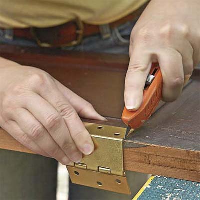new mortices are cut to attach the new hardward where it will fit the shutter's new use as doors