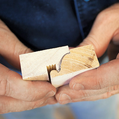 man using sanding block to smooth out rough molding