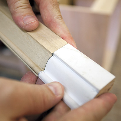 man checking new molding against original molding