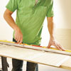 using a straightedge and utility knife to cut the first Lincrusta wainscot panel