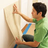 starting to adhere the first Lincrusta wainscot panel to the wall