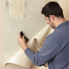 Sal Vaglica stripping wallpaper with a putty knife