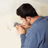 Sal Vaglica scrapes off excess glue residue using a metal putty knife 