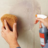 checking for residual adhesive by spraying the wall with povidone iodine and water and wiping with a sponge