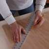 man using ruler to measure poker table