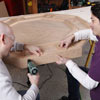 two men attaching apron on poker table