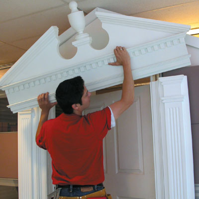 Mark Powers installs a pediment over an office cubicle