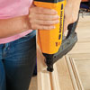securing crown to the repurposed door to make the top of the headboard with a brad nailer