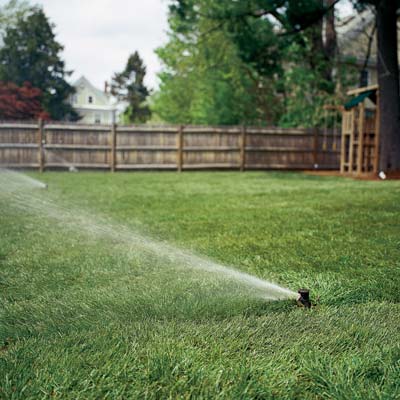 a sprinkler system waters a lawn
