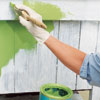 applying a base coat of green paint to a kitchen island before applying faux crackle