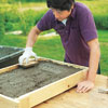 Mark Powers fills the rest of the table frame with the curing hypertufa mix