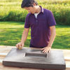 Mark Powers runs a scrap block of wood over hypertufa tabletop to soften rough spots and scrape away leftover foam