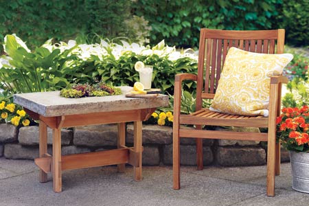 a hypertufa table next to a deck chair on a patio