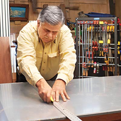 Tom Silva trims the acrylic top with a straightedge and utility knife