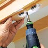 Tom Silva attaches door catches to the shutter doors