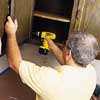 John Dee removing cabinet door with a cordless driver