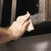sanding the old finish on cabinet frames and wiping with a tack cloth