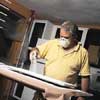 John Dee sprays a fast-dry primer on spots with spackle or bare wood from sanding