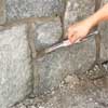 strike the grout lines to clad concrete steps in stone