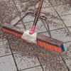 sweeping gravel into the paver cracks for a new driveway