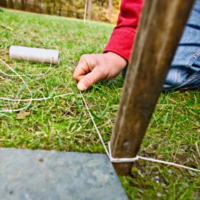 using a stake and mason line for a fixed reference for pavers' height in stepping stone path