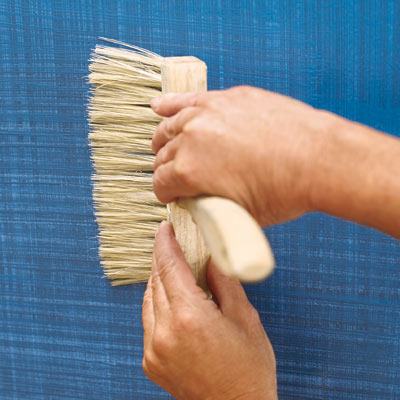 applying horizontal blue glaze crosshatch with a stiff-bristled brush